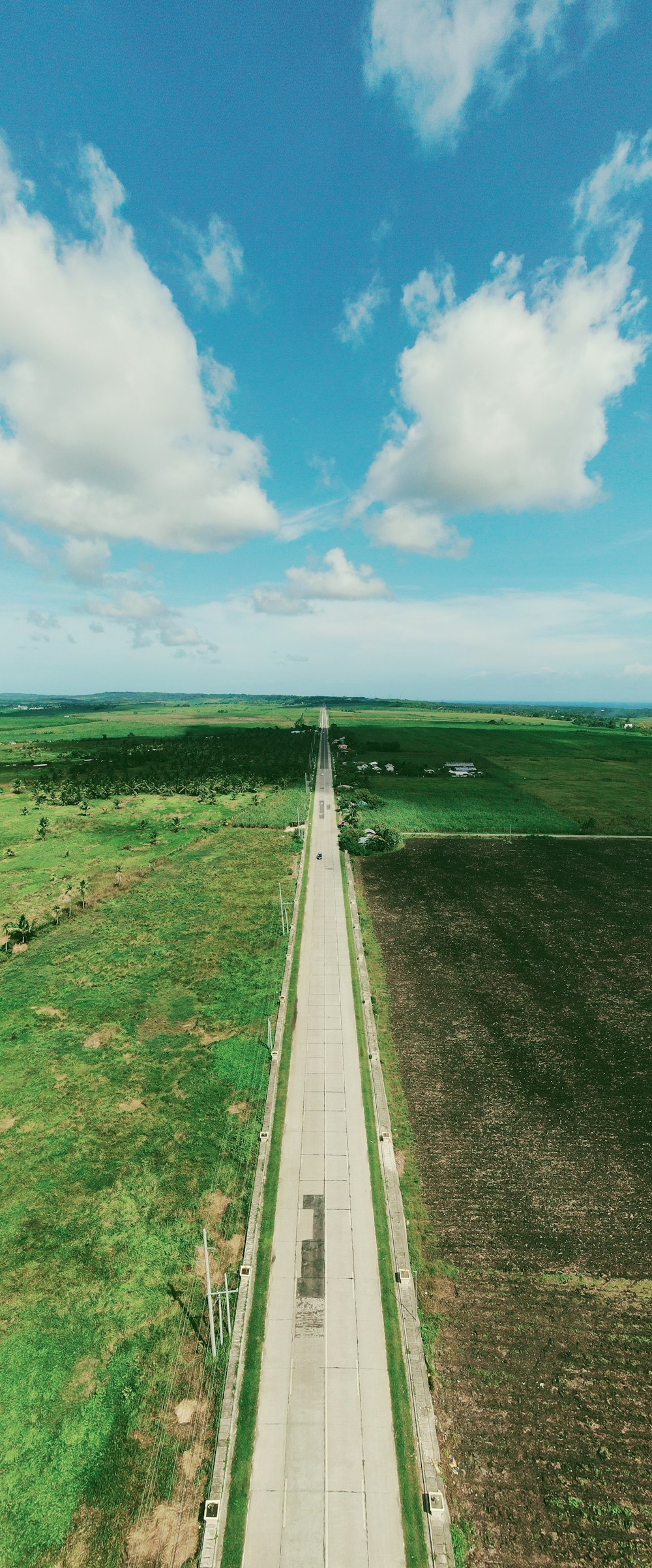 an aerial view of a road in the middle of a field