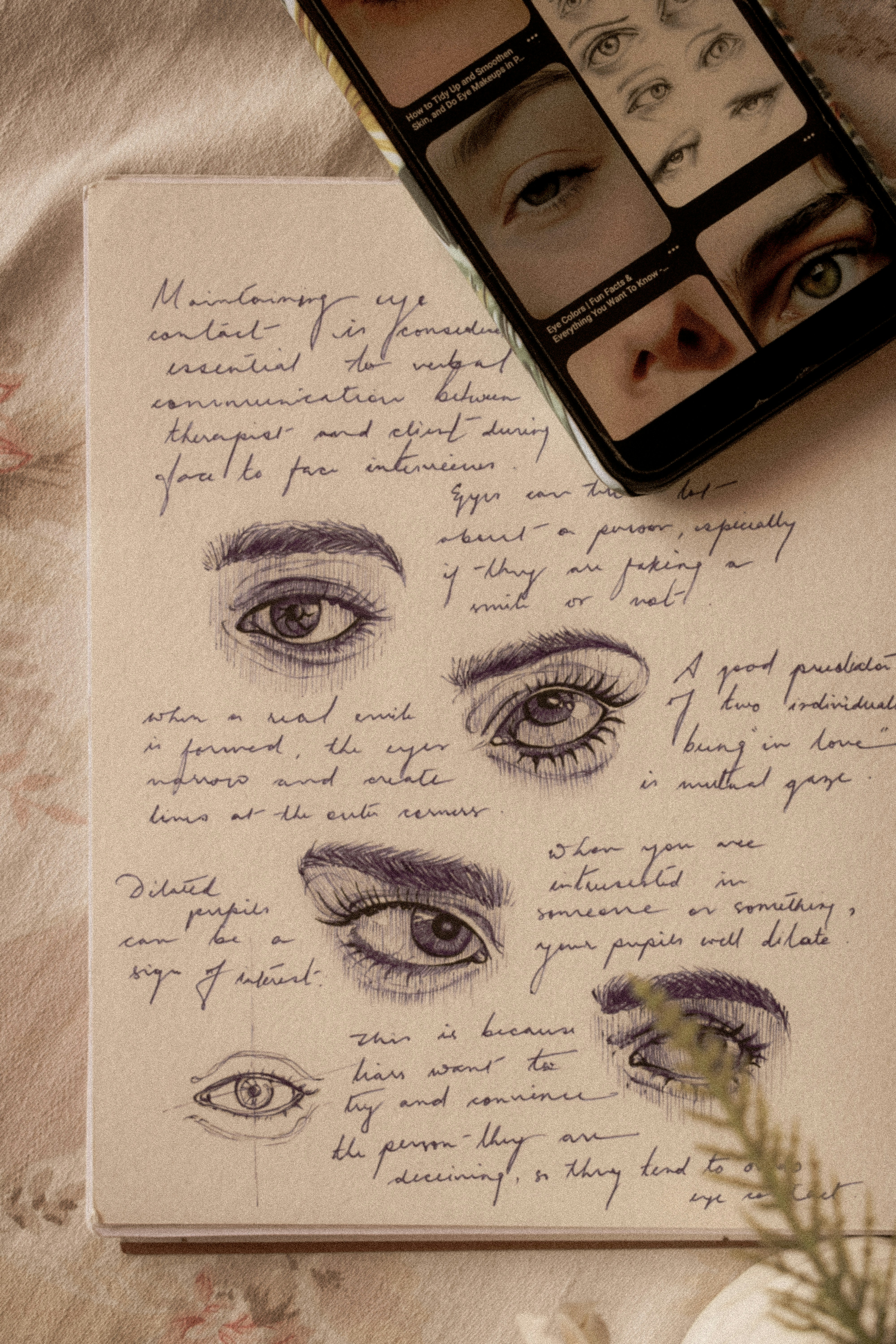 a drawing of a woman's eyes with a cell phone next to it