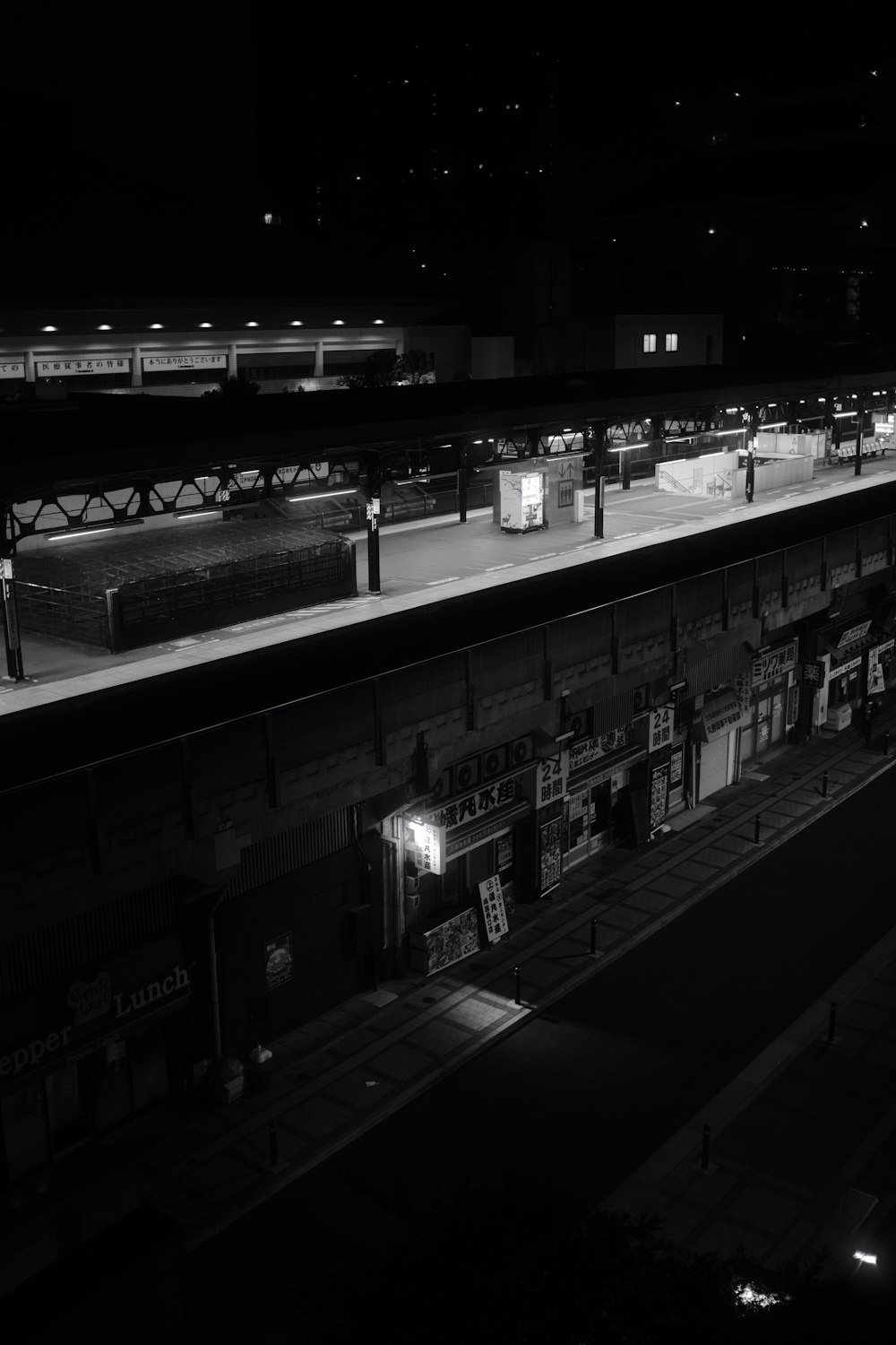 a black and white photo of a train station at night