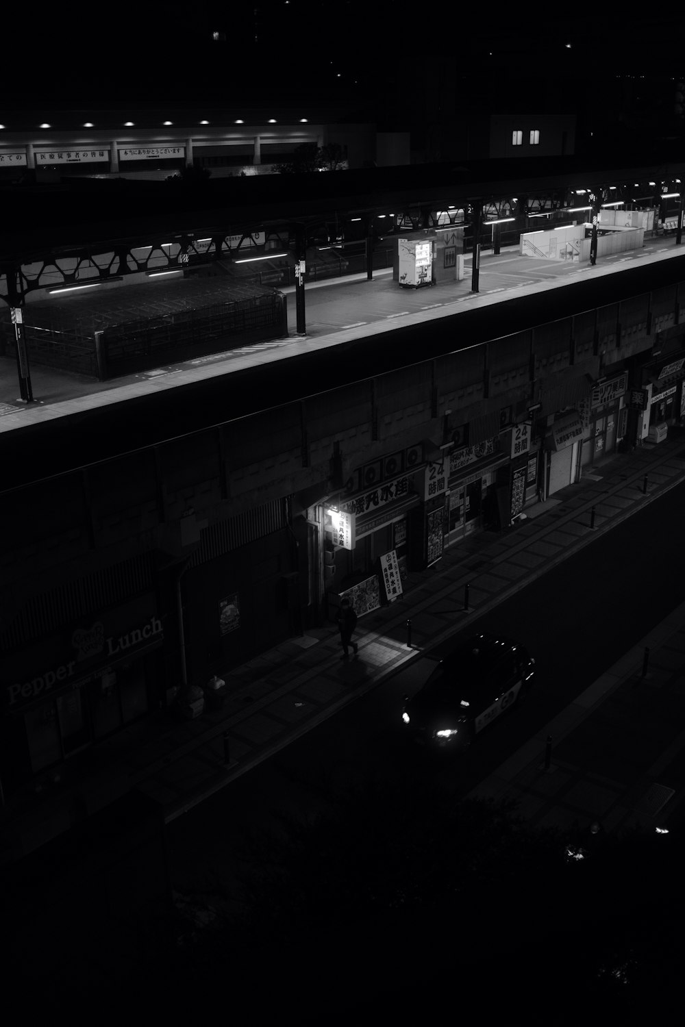 a black and white photo of a train station at night