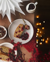 a piece of cake on a plate next to a bowl of cranberry sauce