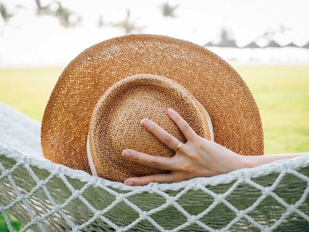 a woman in a hammock with a hat on her head