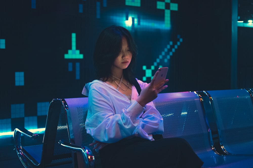 a woman sitting on a bench using a cell phone