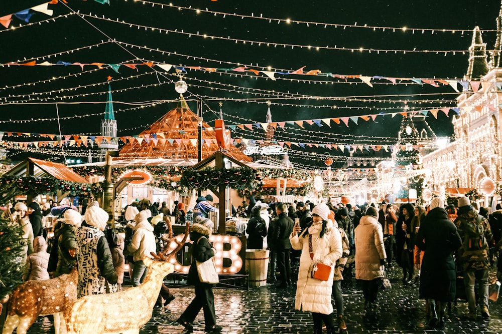 a crowd of people walking around a christmas market