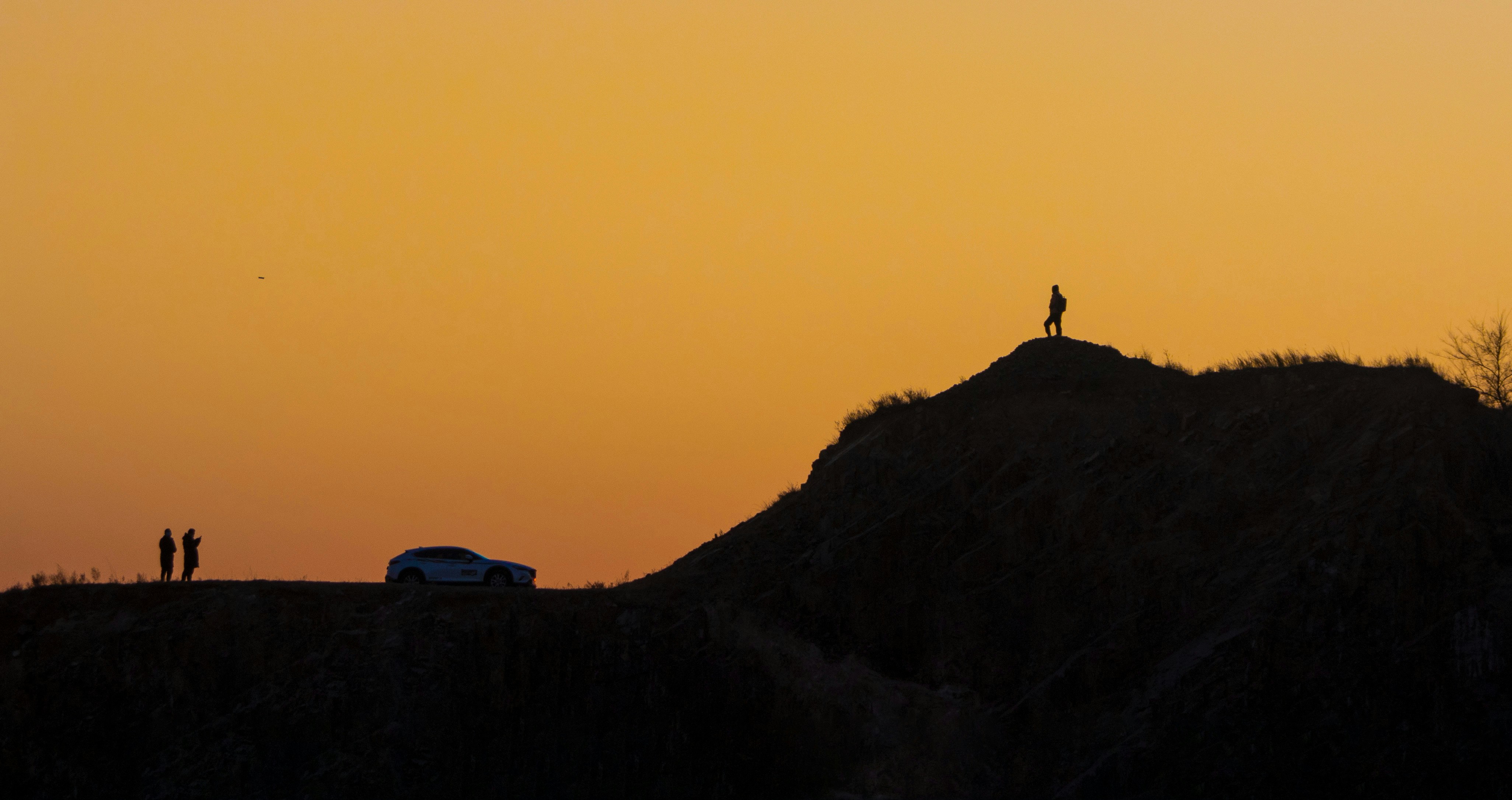 Egy személy, aki egy sziklán áll, kilátással a napkeltére, szimbolizálja az új kezdetet.