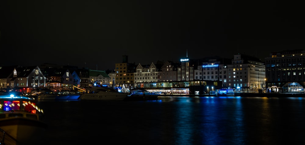 a city at night with a boat in the water