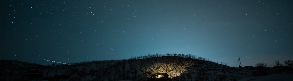 a night sky with stars above a mountain