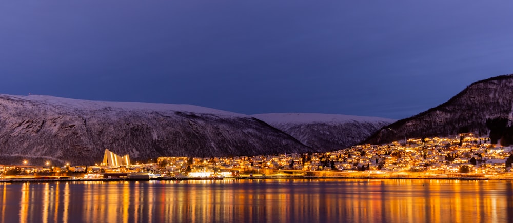 a city is lit up at night by the water