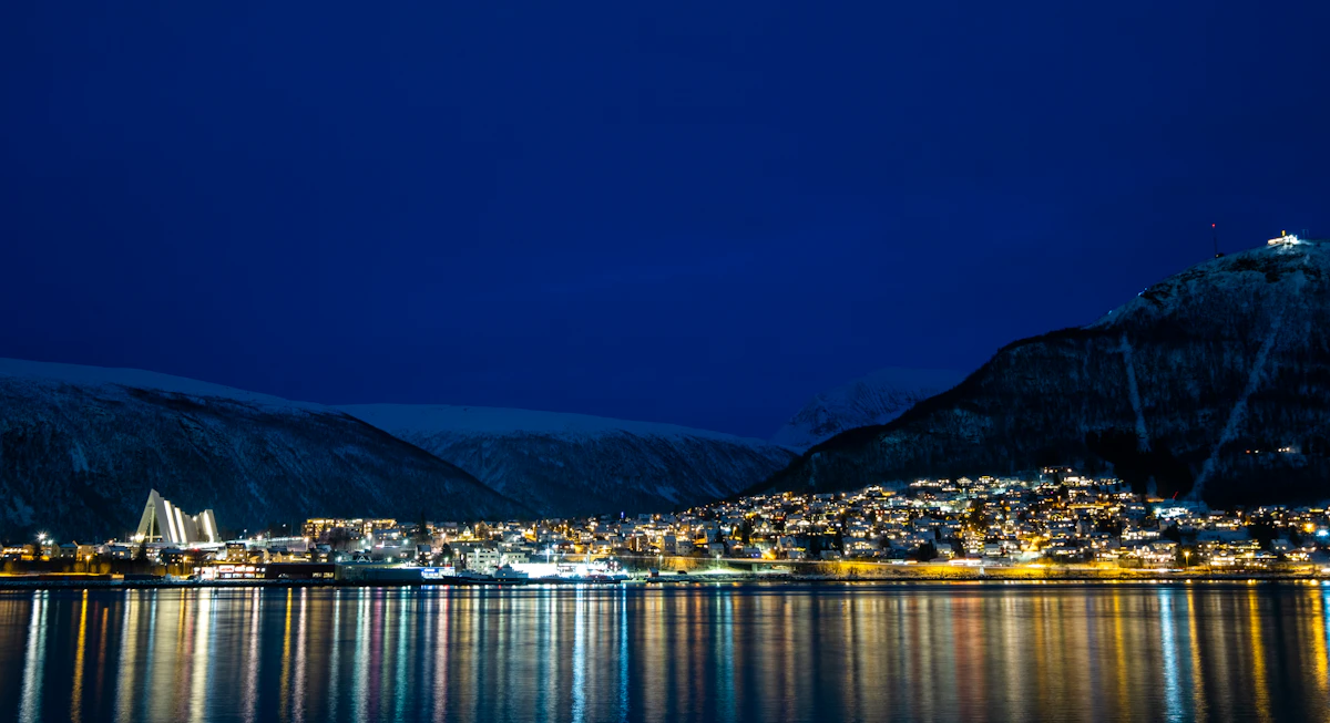 Tromsø bridge and city lights reflected on the water at night
