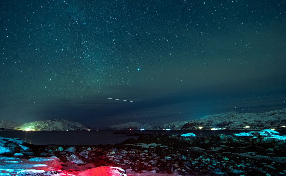 a night sky with stars and a bright red tent in the foreground