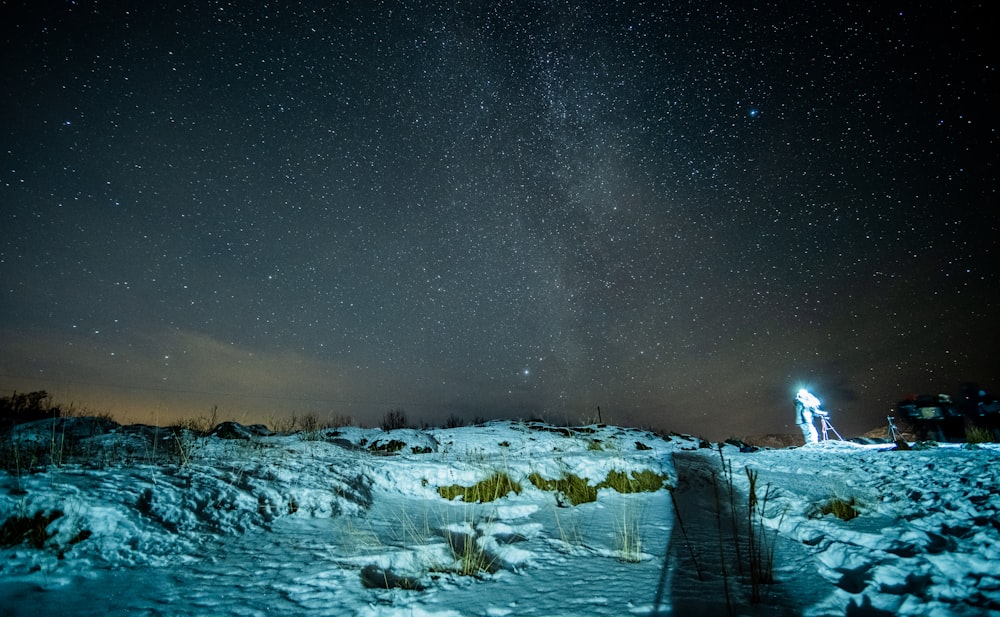 the night sky with stars above a snow covered hill