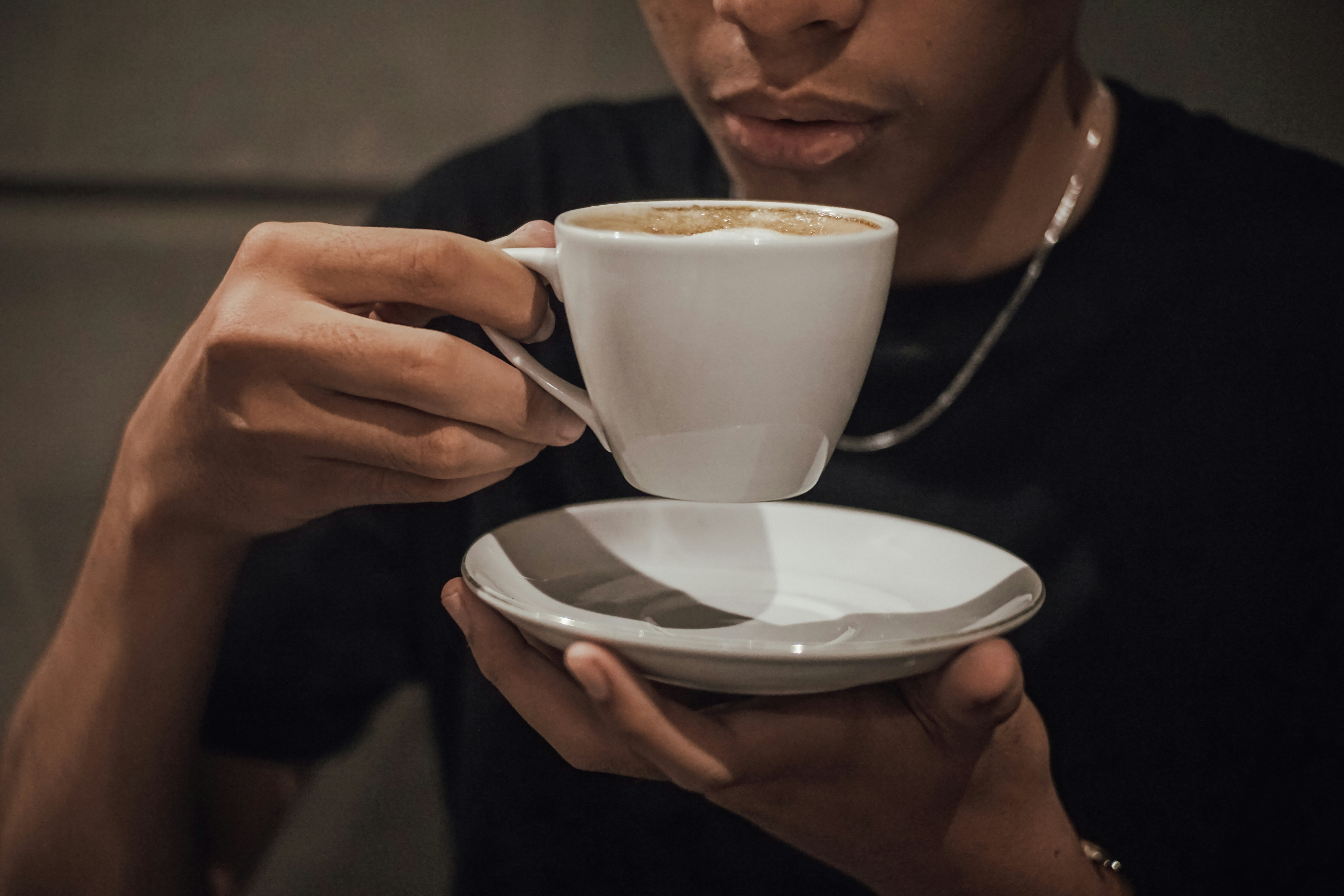 a man is holding a cup of coffee
