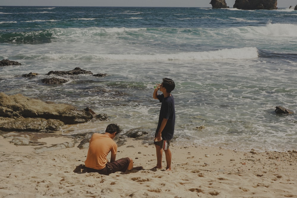 a couple of people that are sitting in the sand