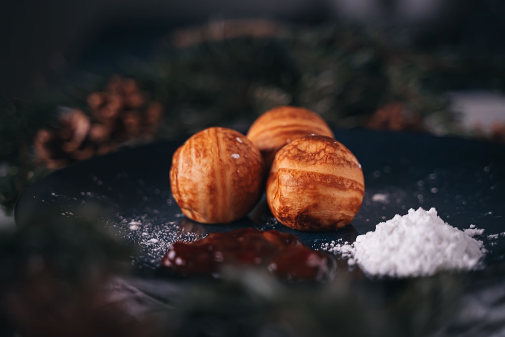 a couple of doughnuts sitting on top of a black plate