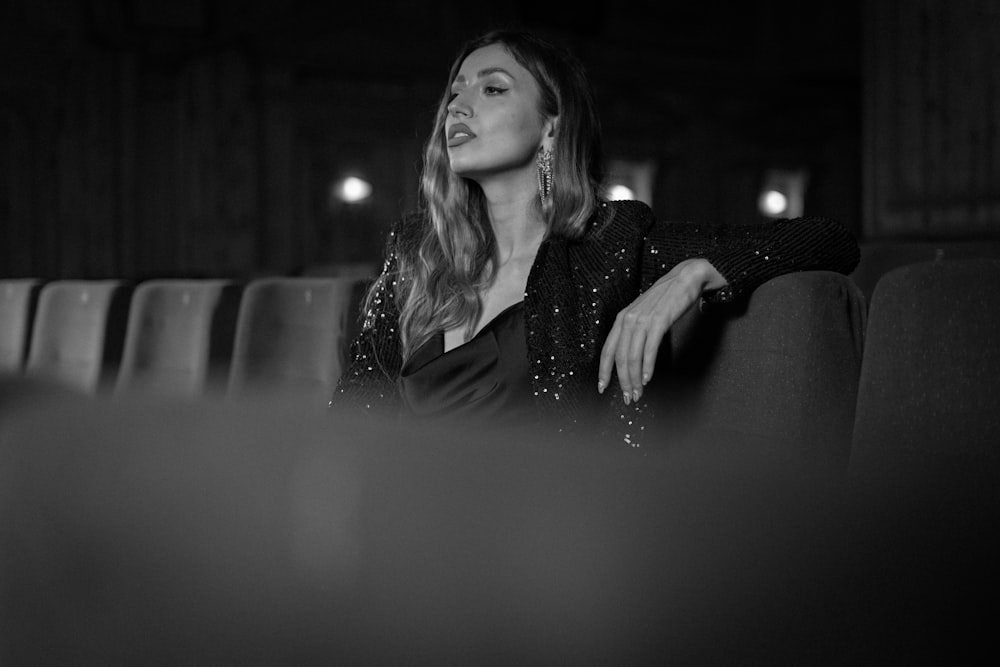 a woman sitting on a couch in a dark room
