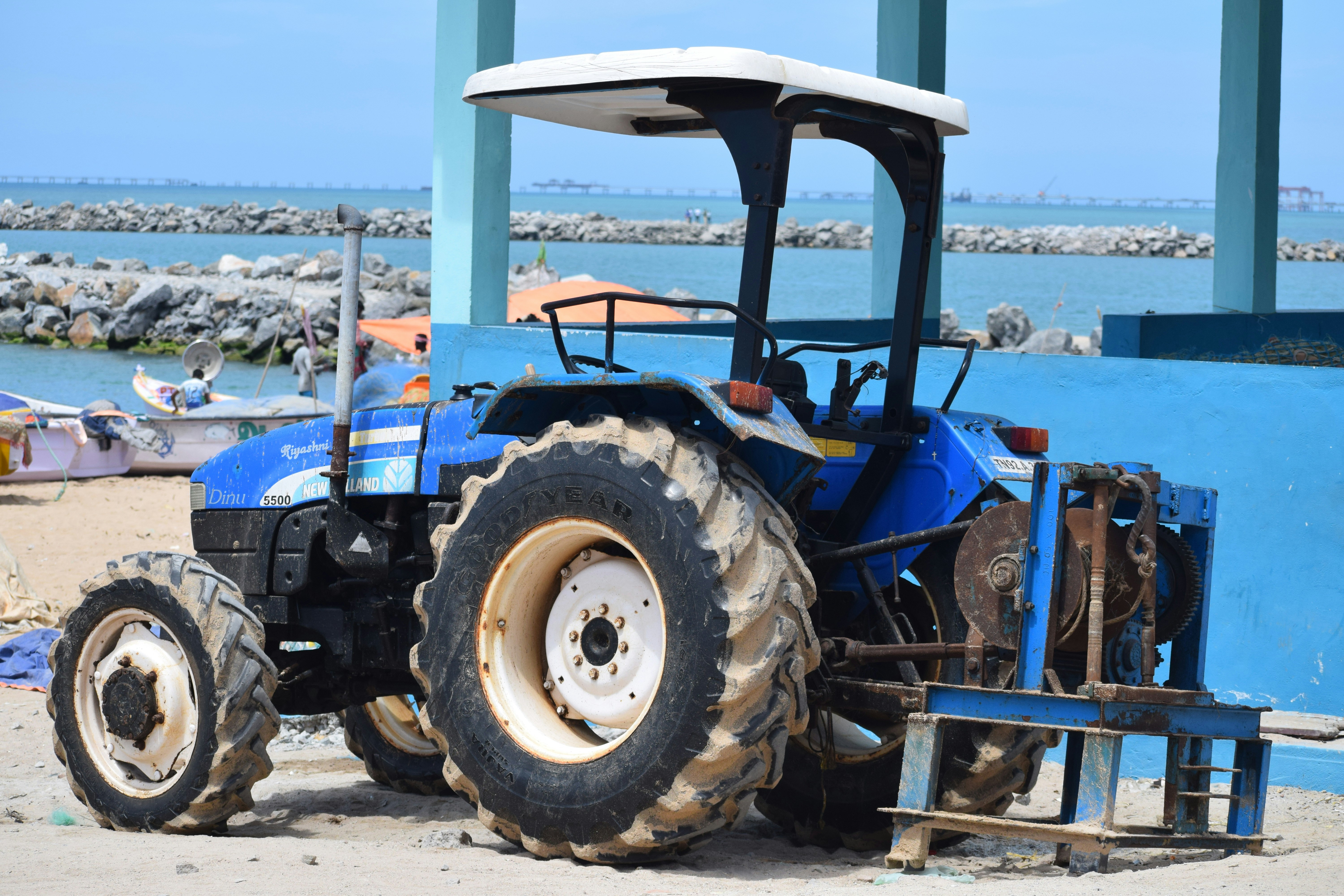 um trator azul estacionado ao lado de uma parede azul