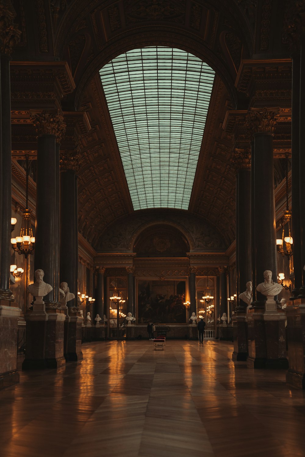 a large room with a skylight and statues