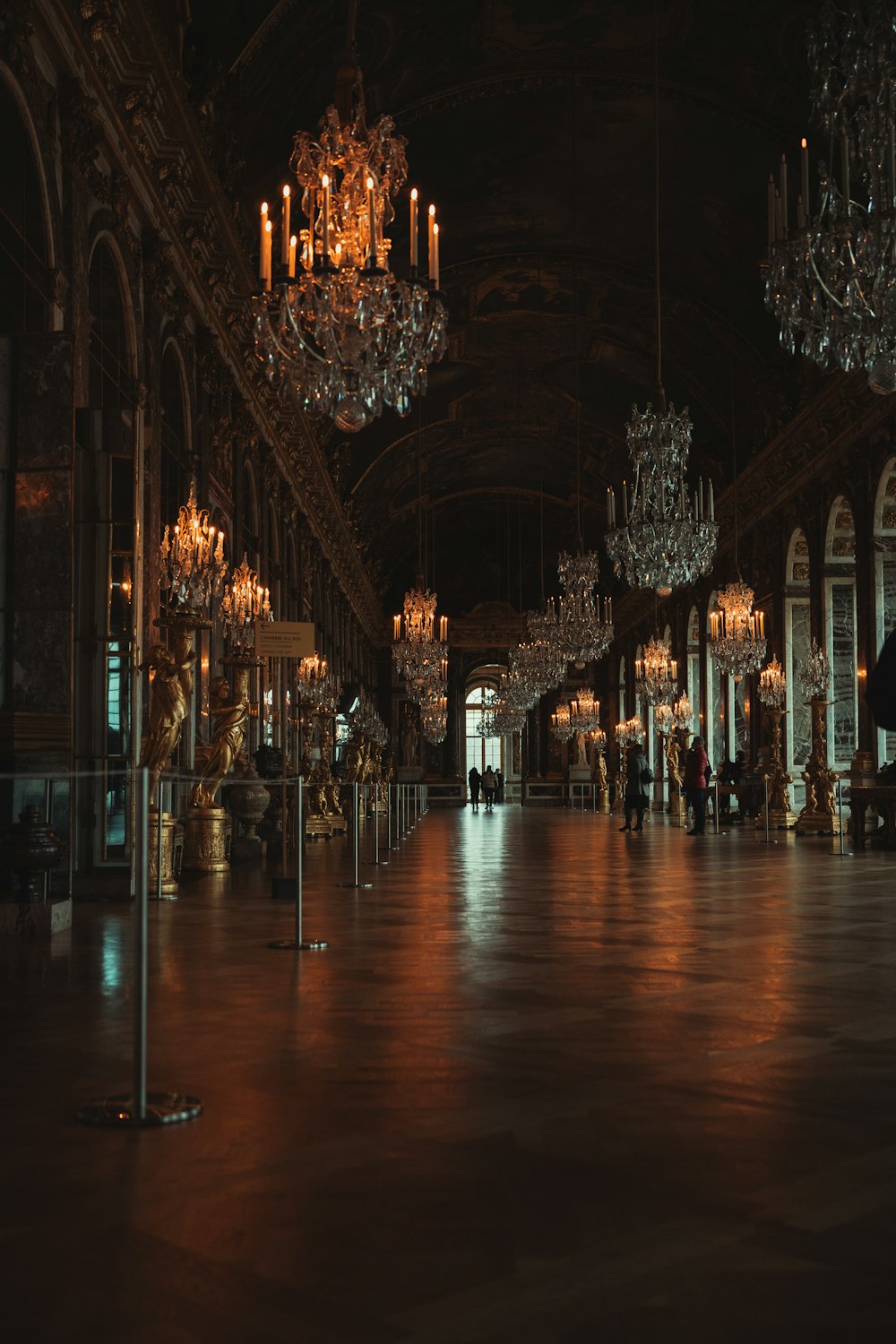 a dark room with chandeliers and chandeliers hanging from the ceiling
