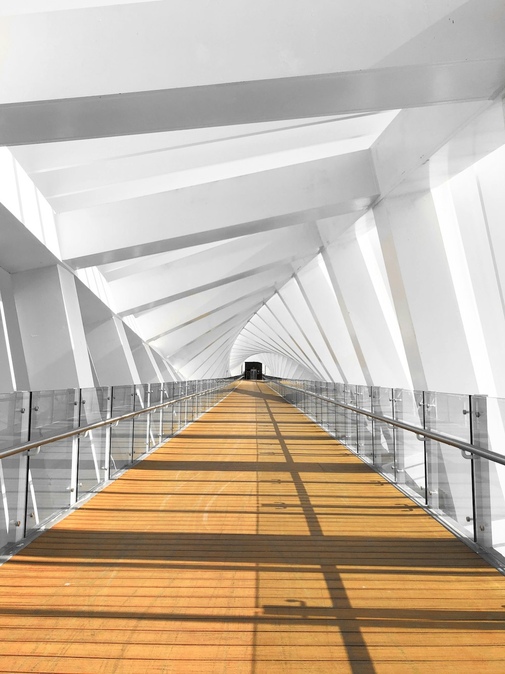 a wooden walkway with a metal hand rail