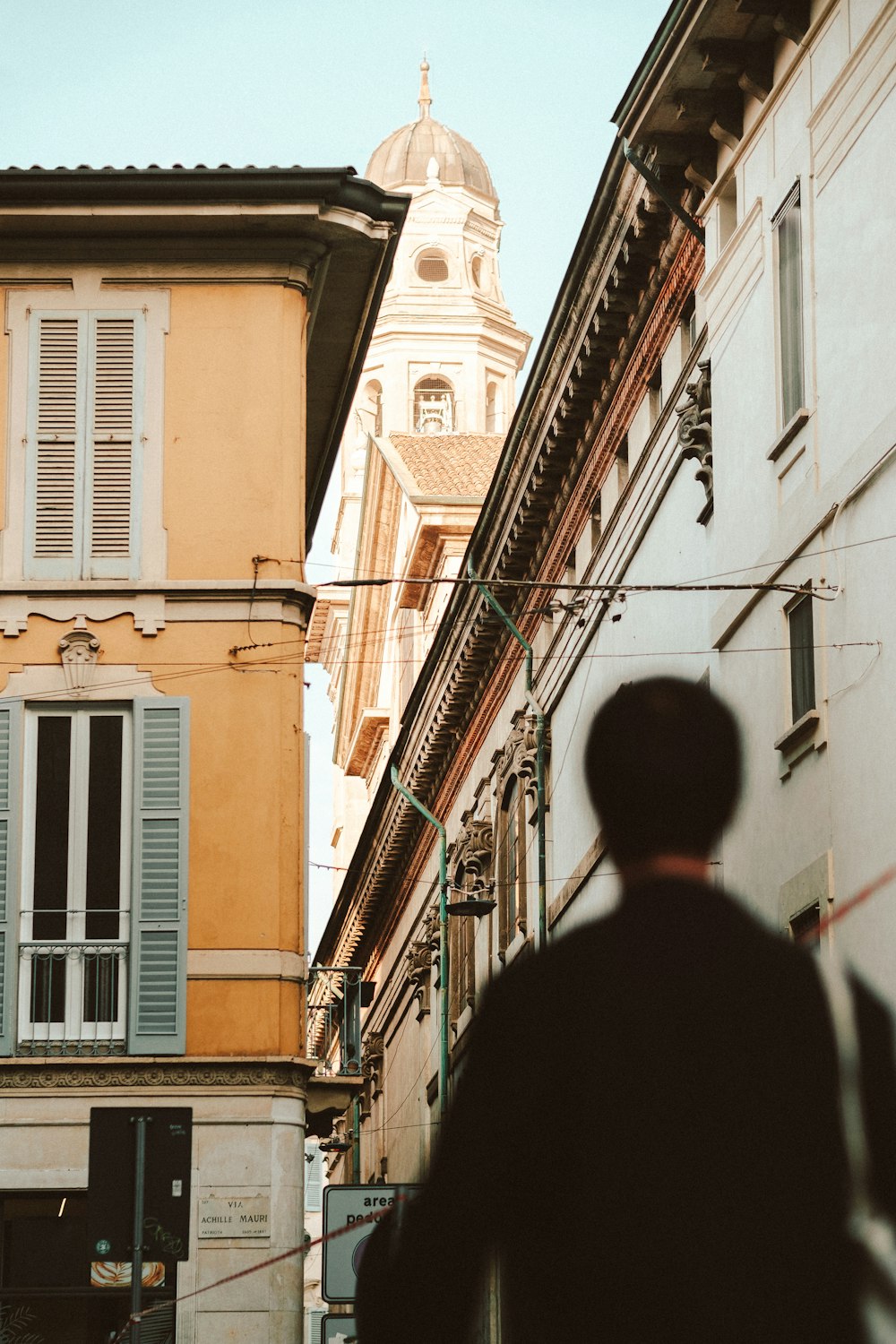 a man walking down a street next to tall buildings