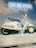 A happy customer showcasing their Vespa-themed wallpaper on a smartphone.