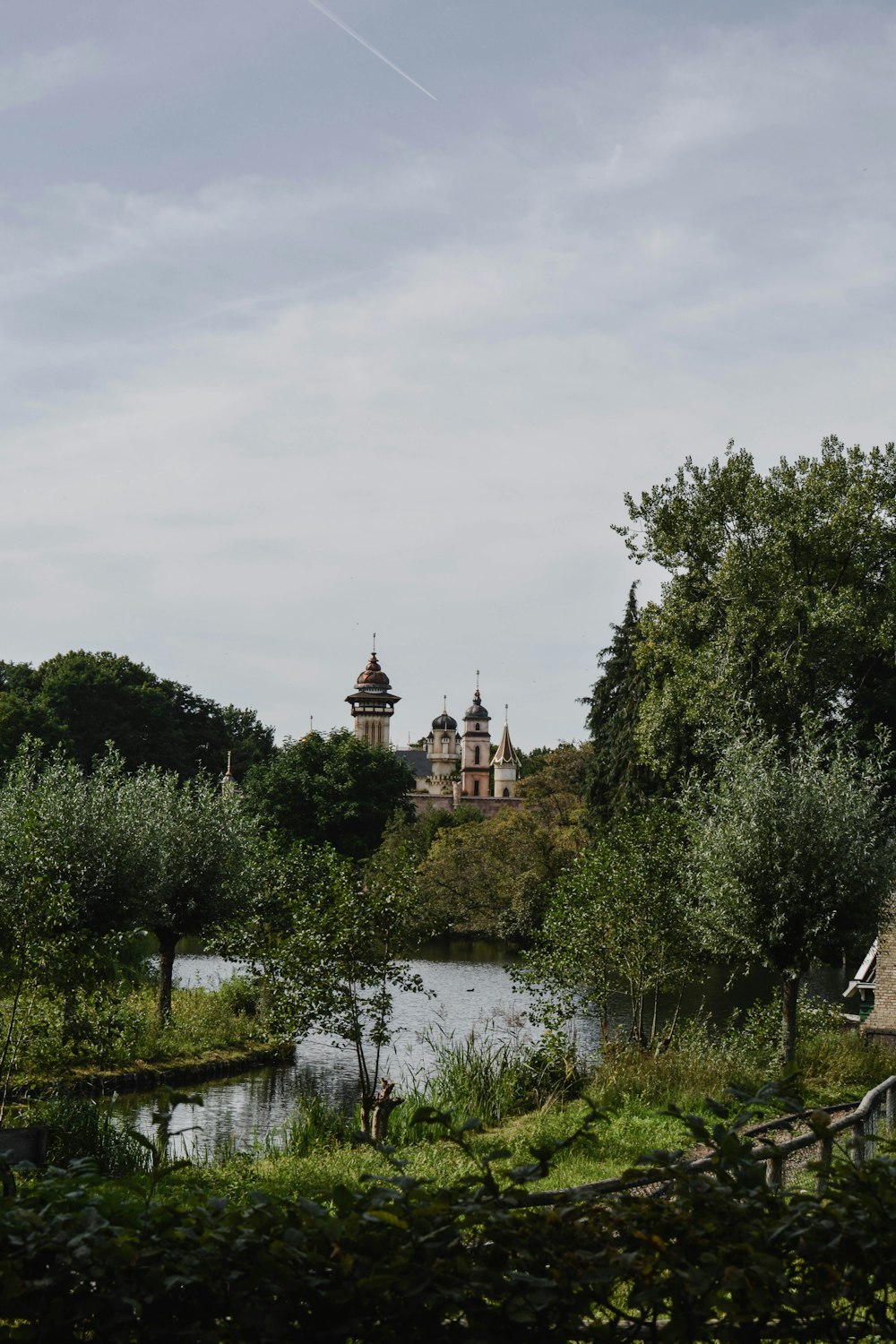 a lake surrounded by trees with a castle in the background