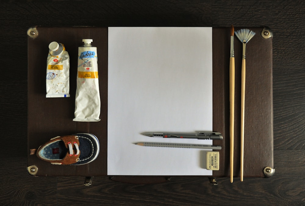a notepad, pencils, and a pair of scissors sit on a desk