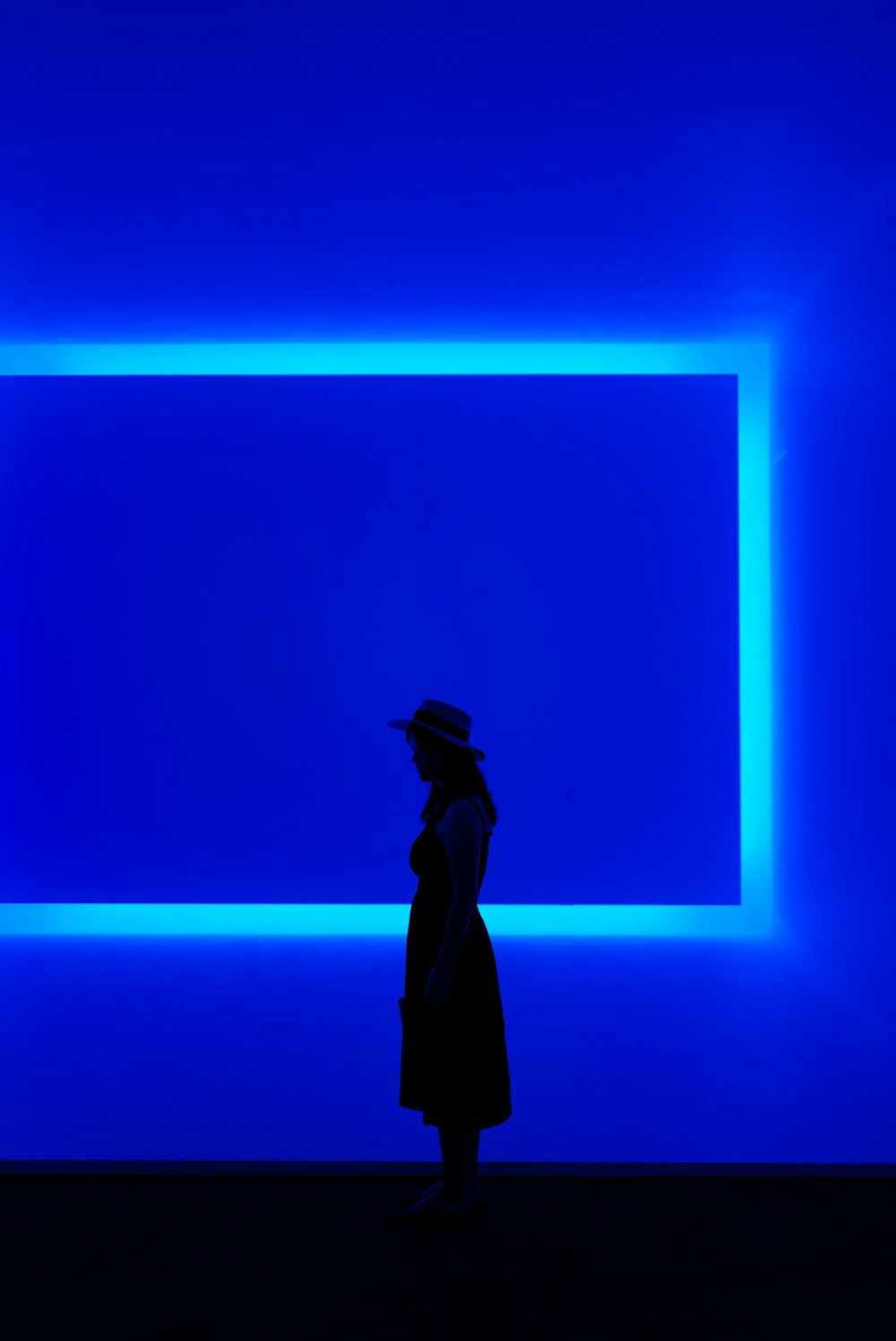 une personne debout devant un mur bleu