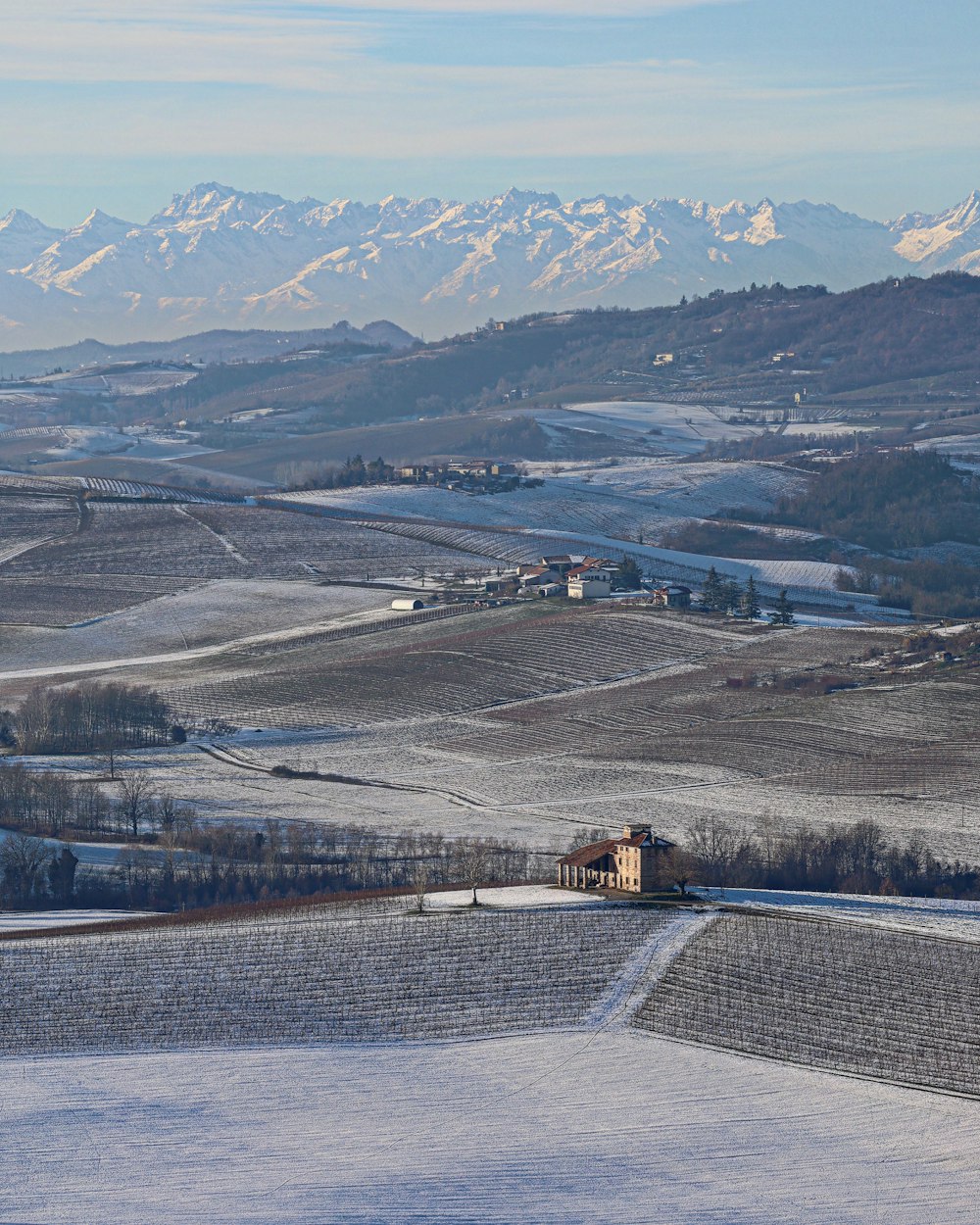 a snowy landscape with mountains in the background