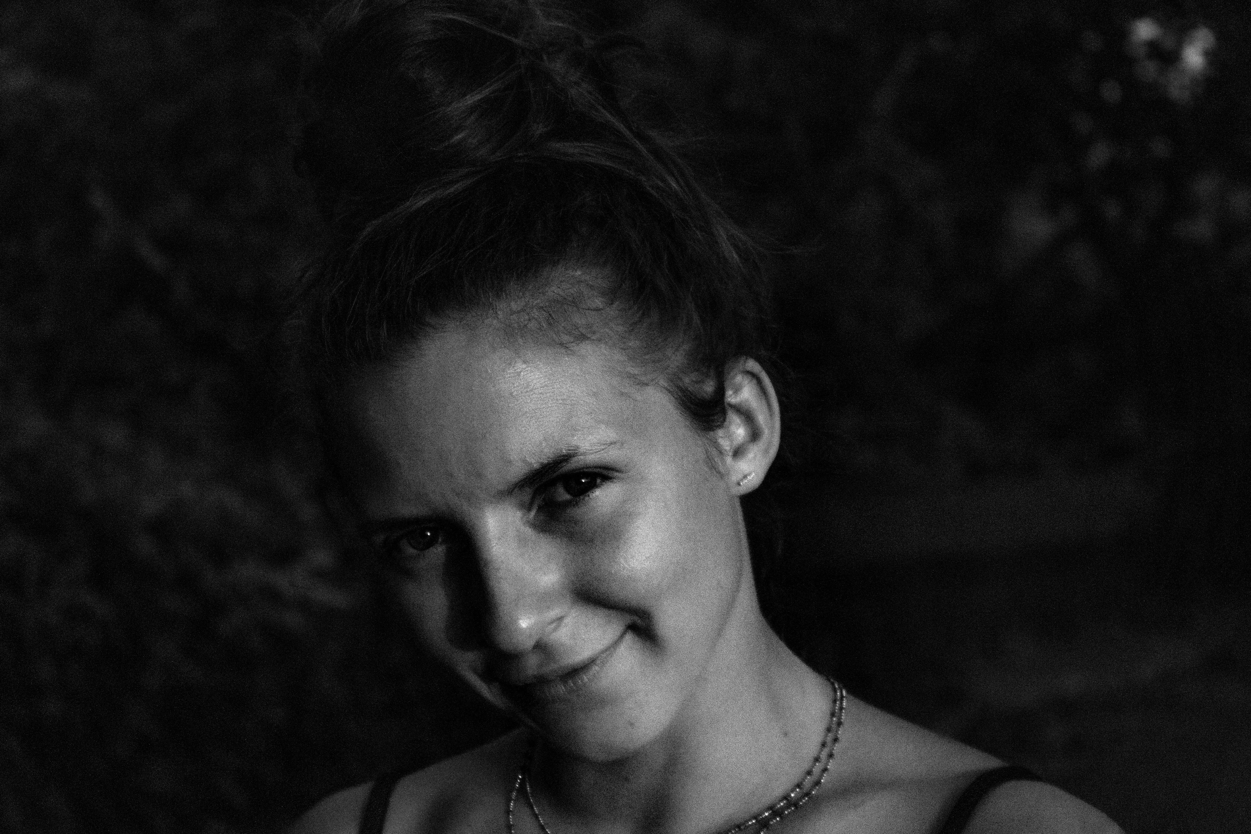 a black and white photo of a woman wearing a necklace