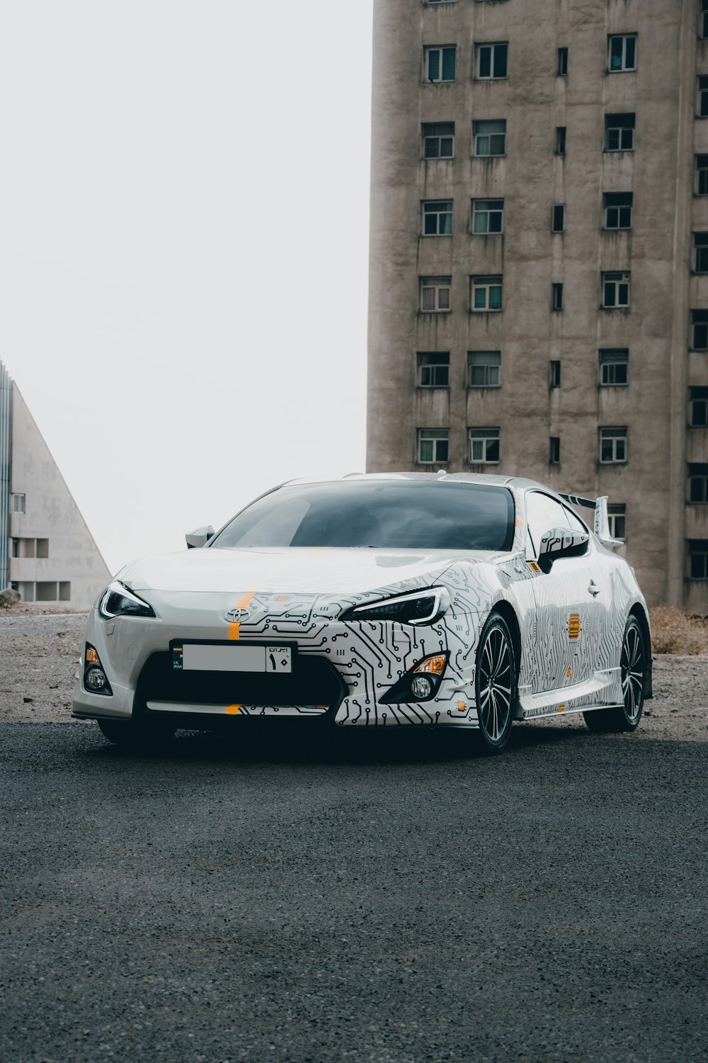 a white sports car parked in front of a tall building