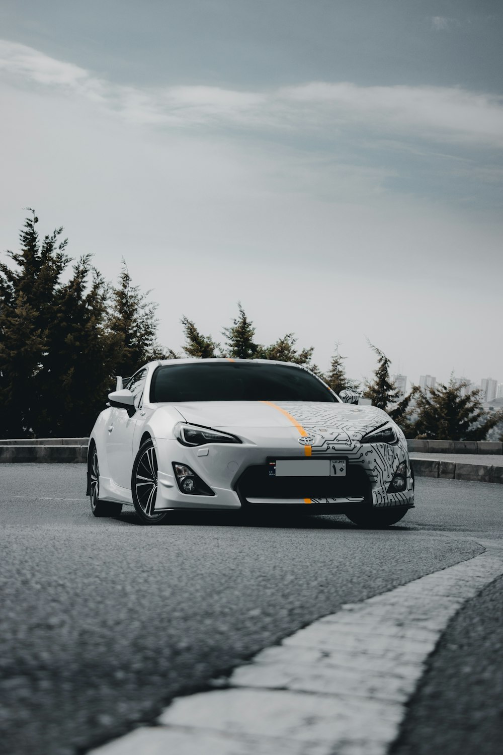 a white sports car driving down a road