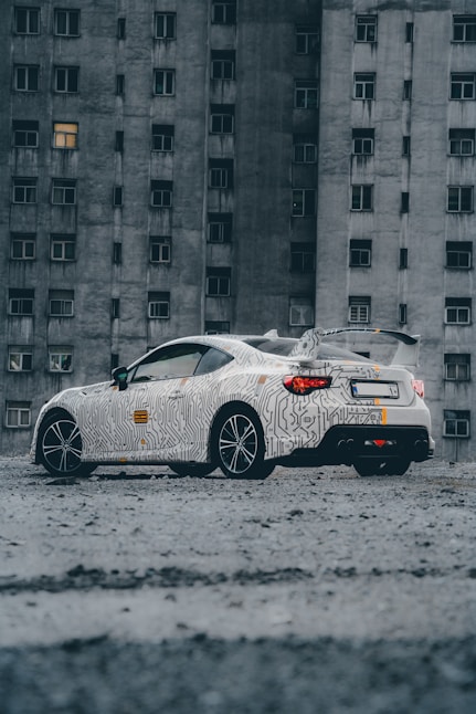 a white car parked in front of a tall building