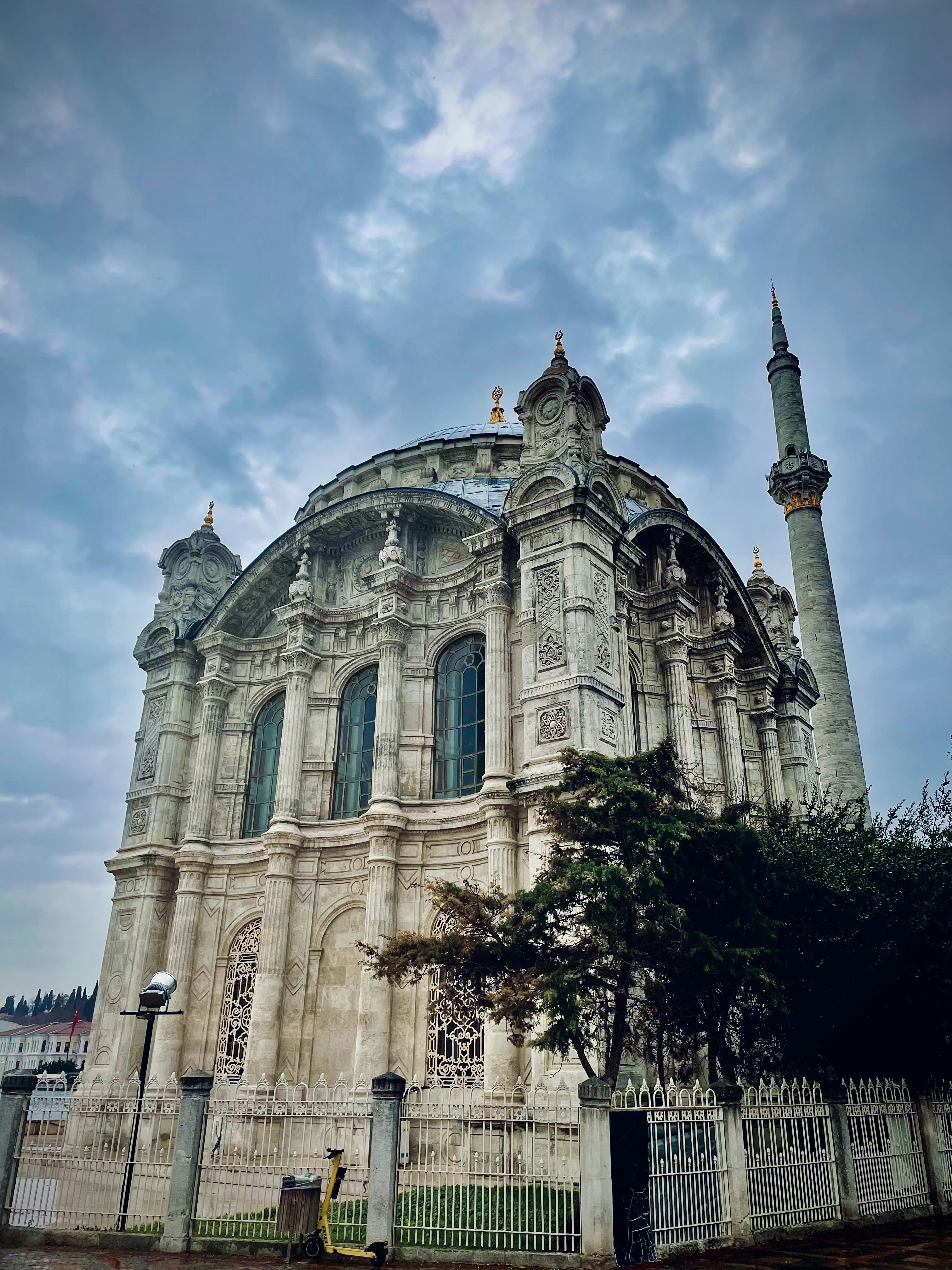 a large building with a tall tower next to a fence