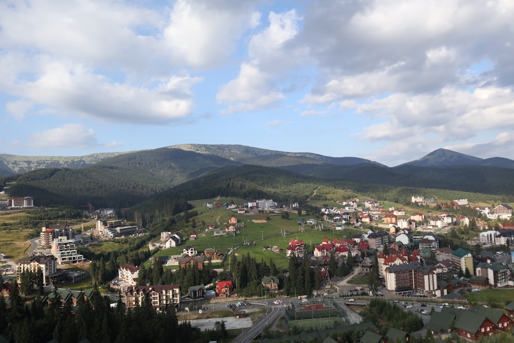 a town surrounded by mountains under a cloudy sky