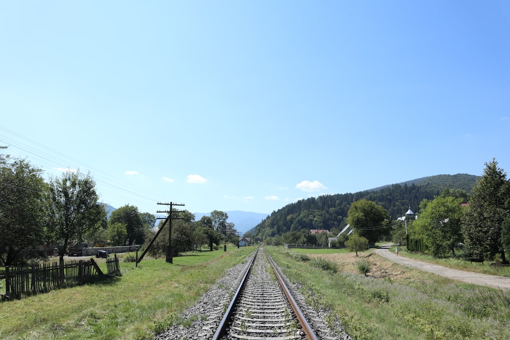 a train track running through a lush green countryside