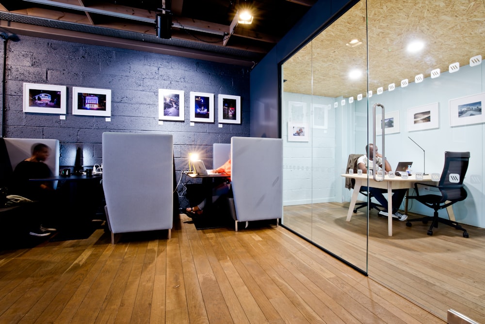 an office with a glass wall and wooden floors