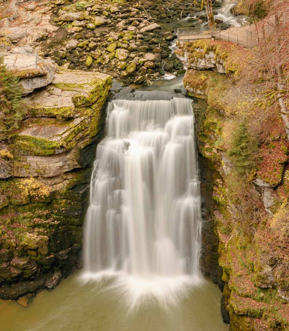 a waterfall is seen through a crack in the rocks