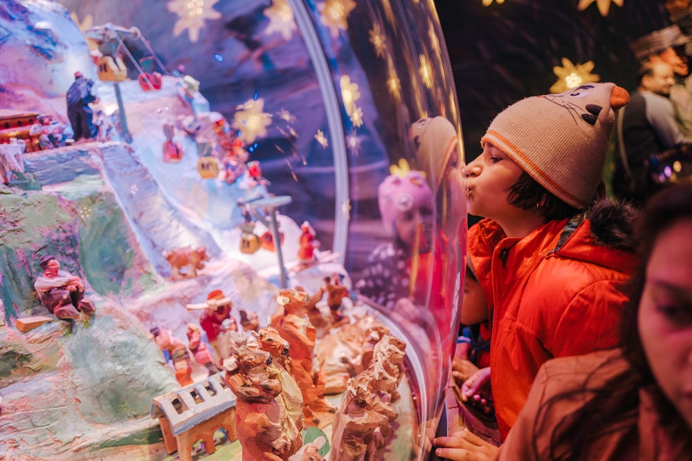 a little girl looking at a snow globe