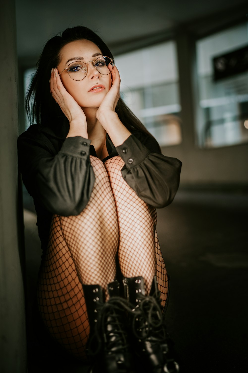 a woman wearing fishnet stockings and black boots