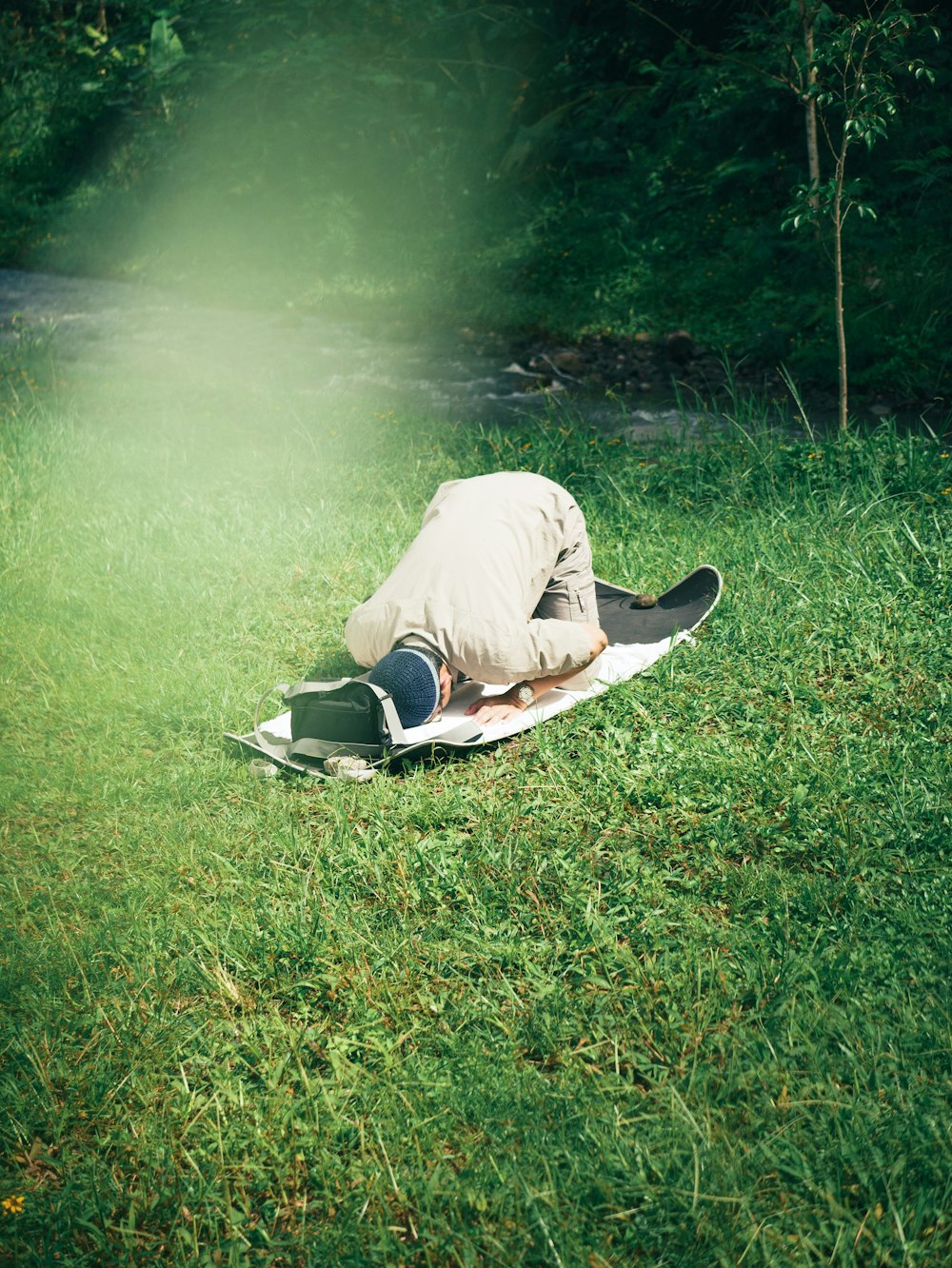a man laying on top of a surfboard on top of a lush green field