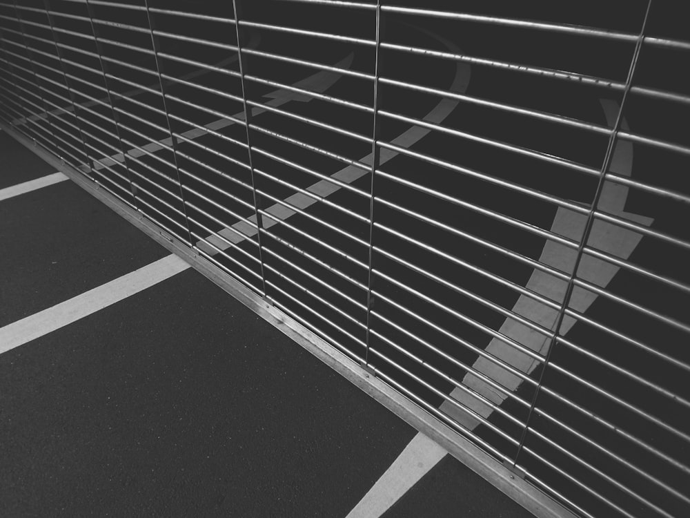 a black and white photo of a metal fence