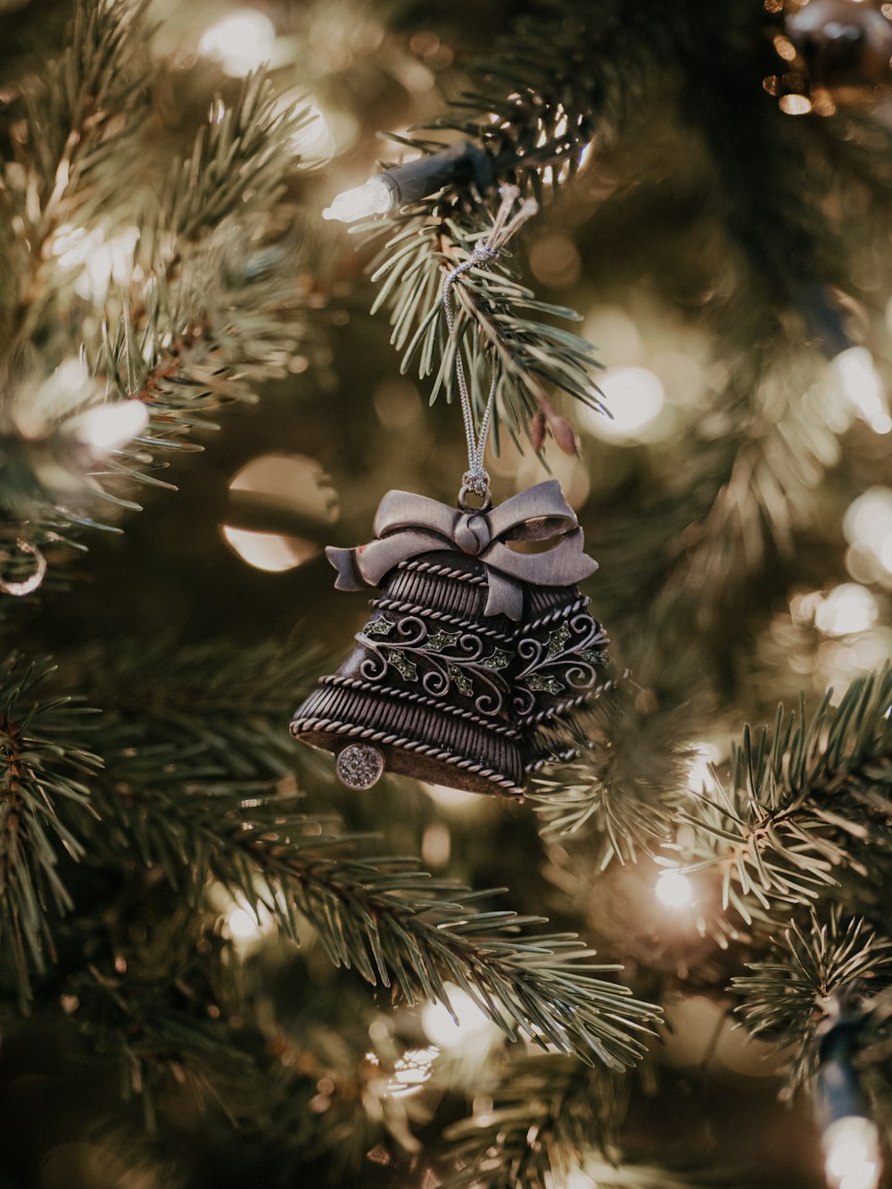 a bell ornament hanging from a christmas tree