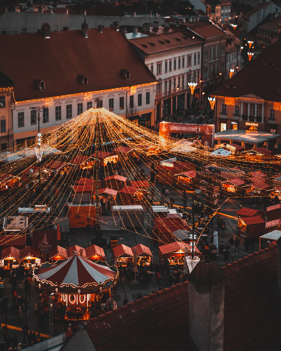 Marché de Noël avec des échoppes illuminées le soir, vu d'en haut