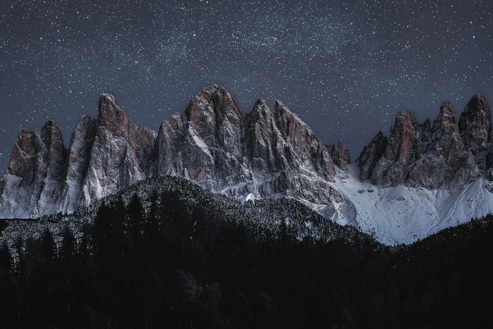 the night sky over a snowy mountain range