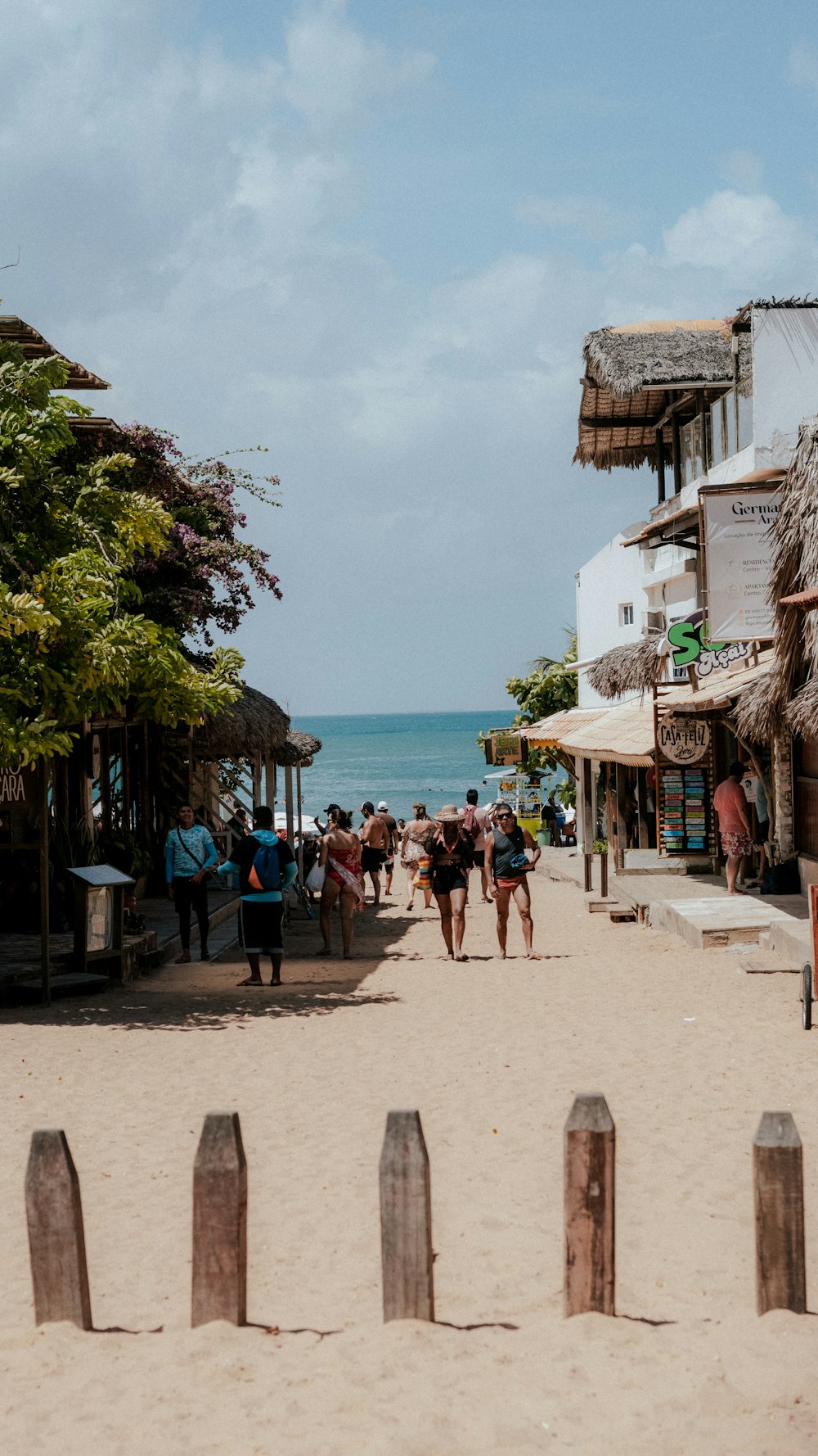 a group of people walking down a sandy beach