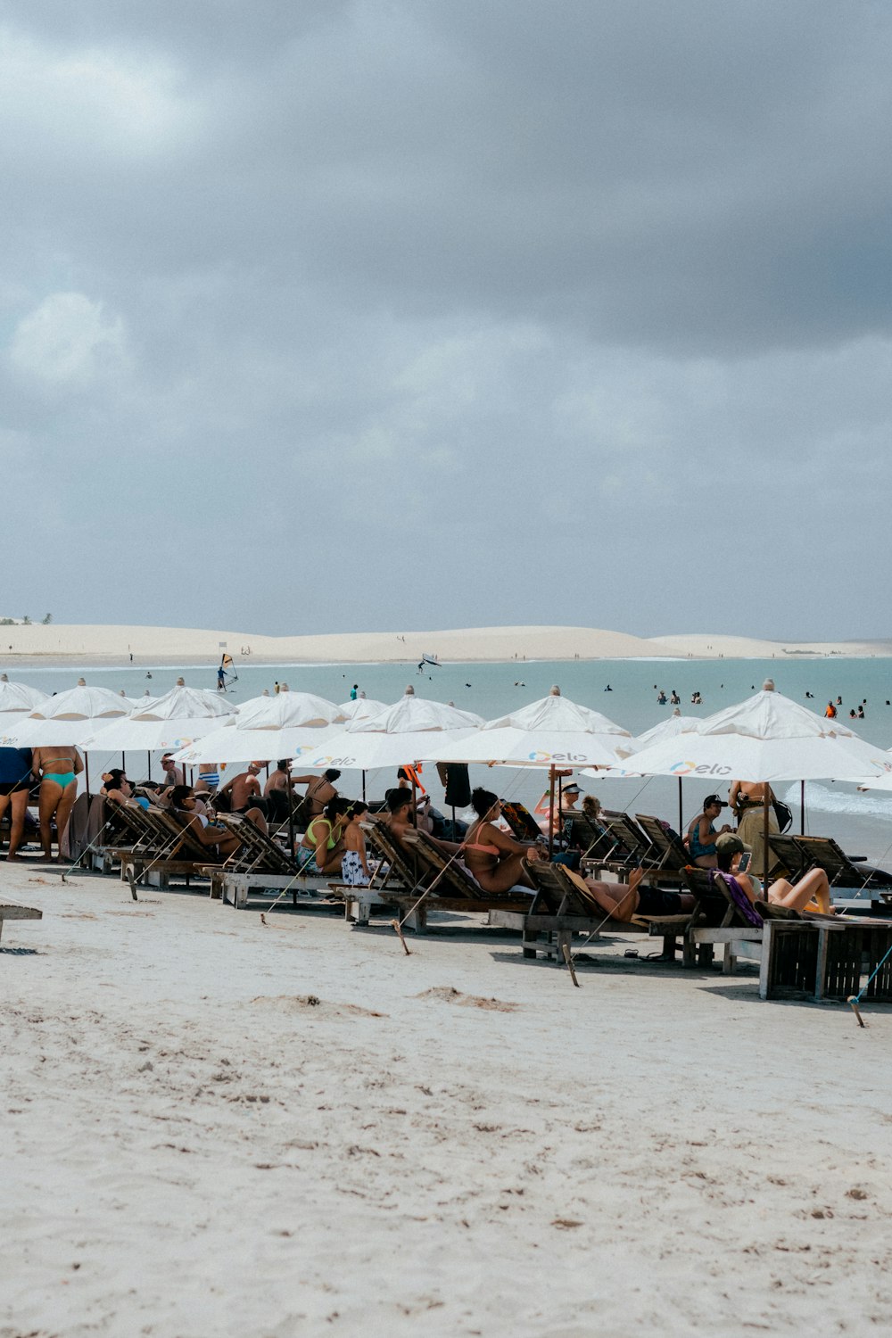 a group of people sitting under umbrellas on a beach