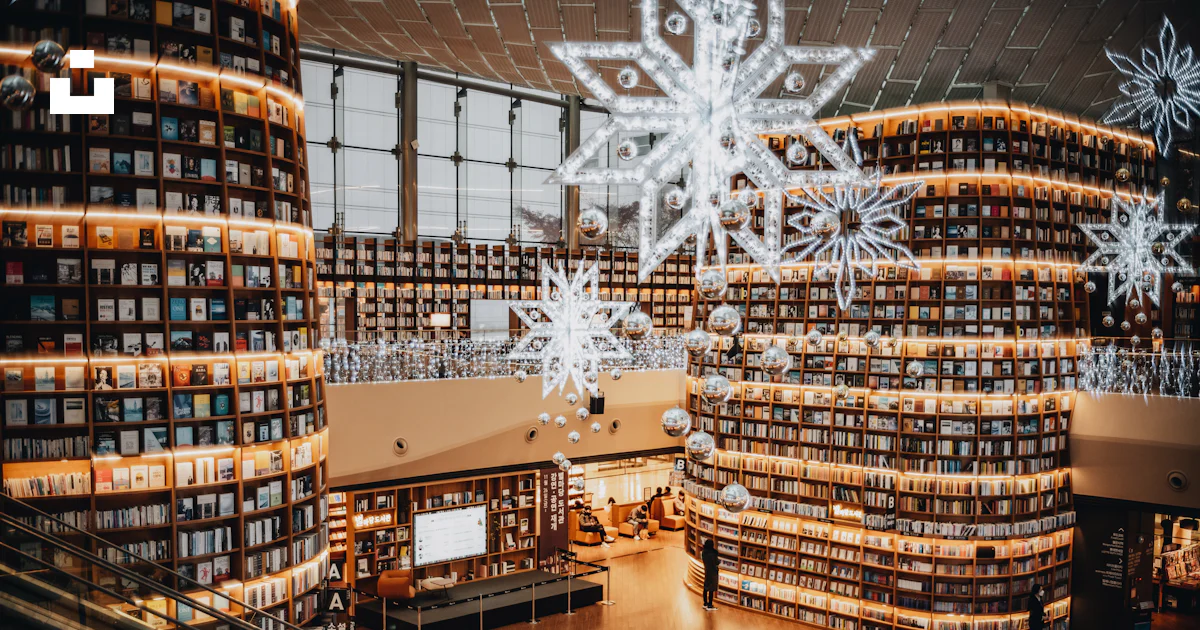 A large library filled with lots of books photo – Free Human Image on ...