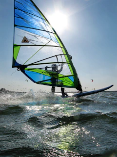 A thrilling moment of windsurfing with a colorful sail cutting through ocean waves.