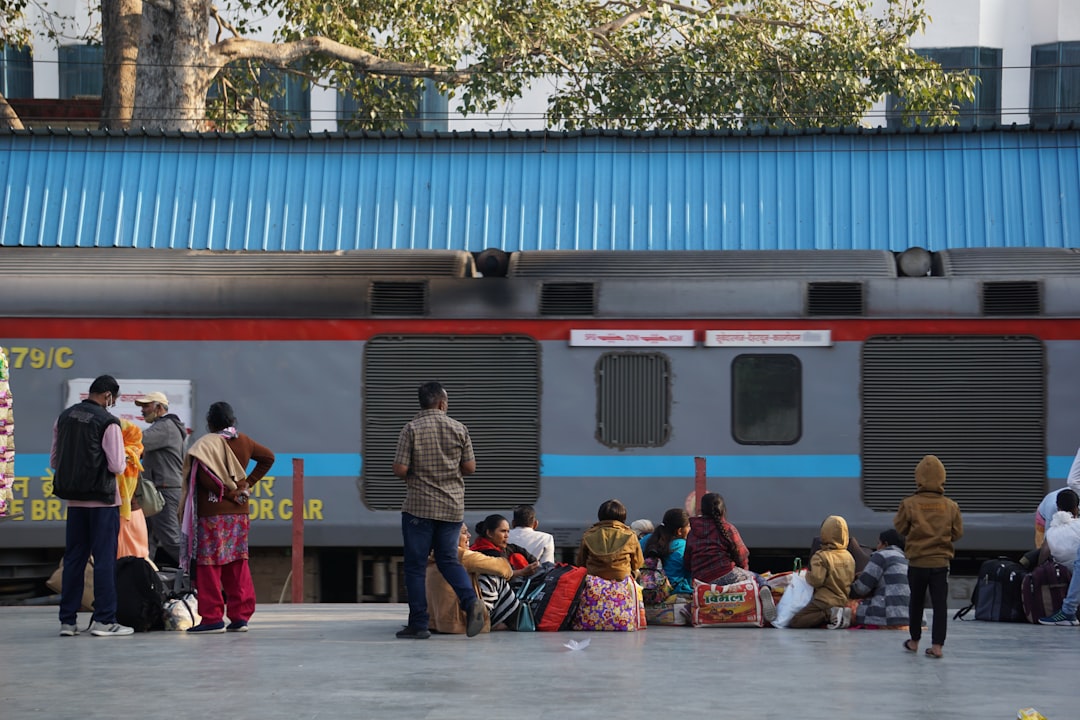 a group of people standing next to a train,
